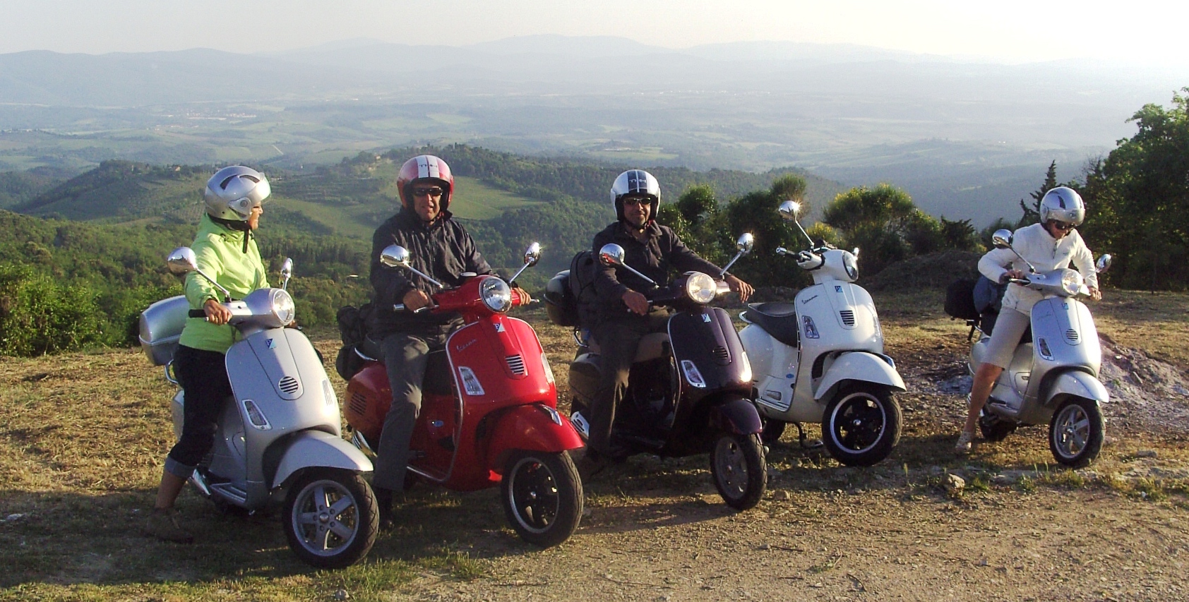 a group of friends happy at the end of their journey by Vespa