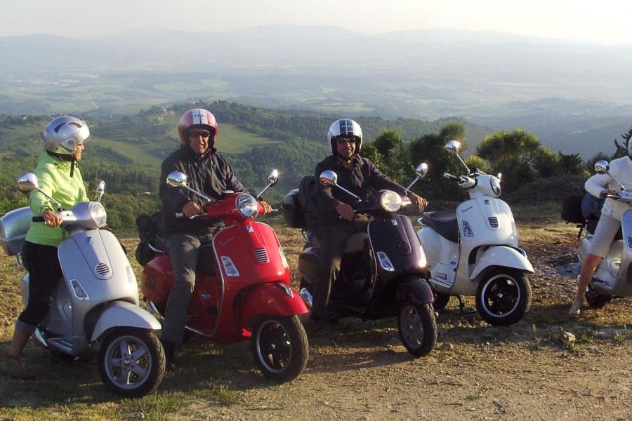 a group of friends happy at the end of their journey by Vespa